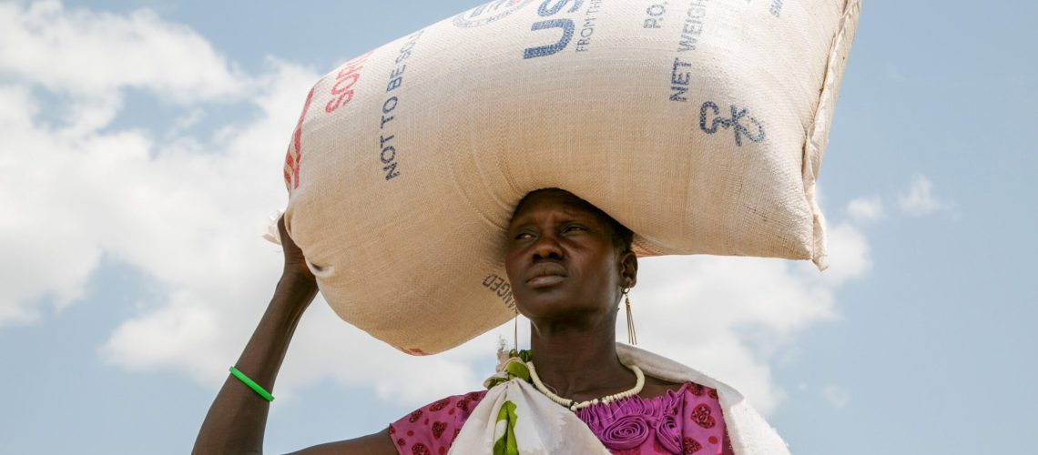 A woman is pictured in a file photo carrying food provided by USAID in Pajut, South Sudan. As the United States paused foreign assistance to countries across the world in January 2025, confusion, panic and desperation has gripped many organizations that benefit from the funds, including church-based groups. (OSV News photo/Nancy McNally, Catholic Relief Services)
